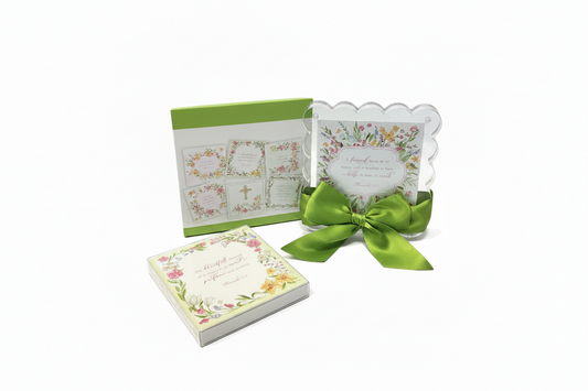 A set of floral-themed religious stationery, including a small square card stack with a cream floral border, a larger square card with a green cover, and a clear scalloped invitation card tied with a bright green satin bow, all on a white background.