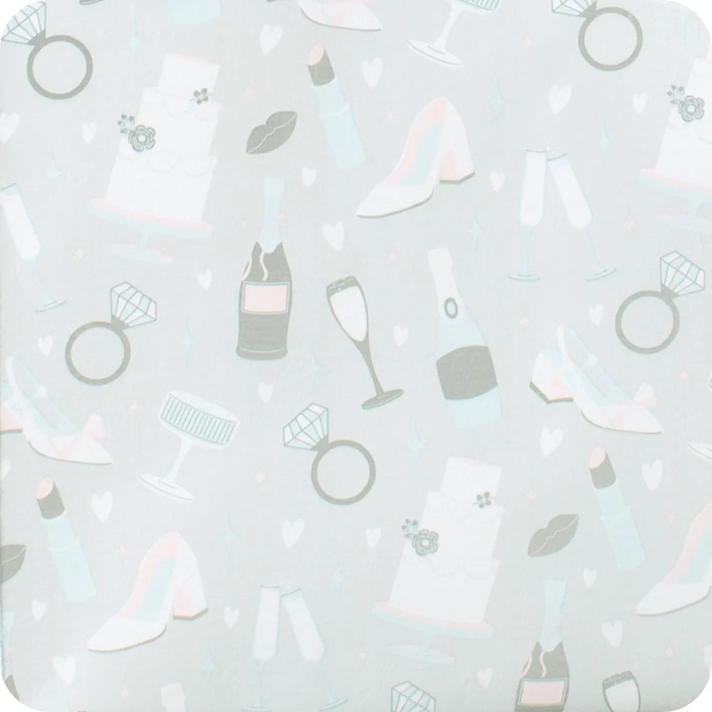 A close-up of a light gray fabric or paper surface printed with a repeating pattern of wedding-themed icons, including rings, high heels, champagne bottles, champagne glasses, lipstick, and small hearts in soft pastel tones. wedding. bride. engagement. congrats.