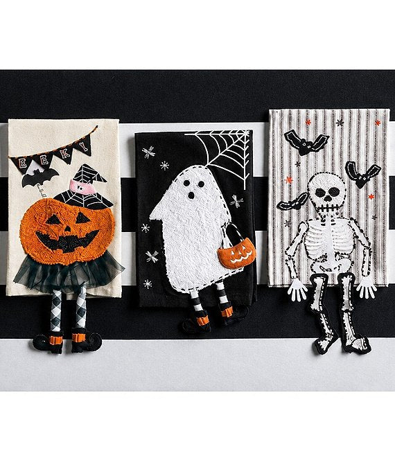Three Halloween-themed embroidered fabric pieces displayed side by side against a black and white striped background. The left piece shows a witch with a large orange jack-o'-lantern; the middle shows a white ghost holding an orange pumpkin; the right shows a black-and-white skeleton with bats.