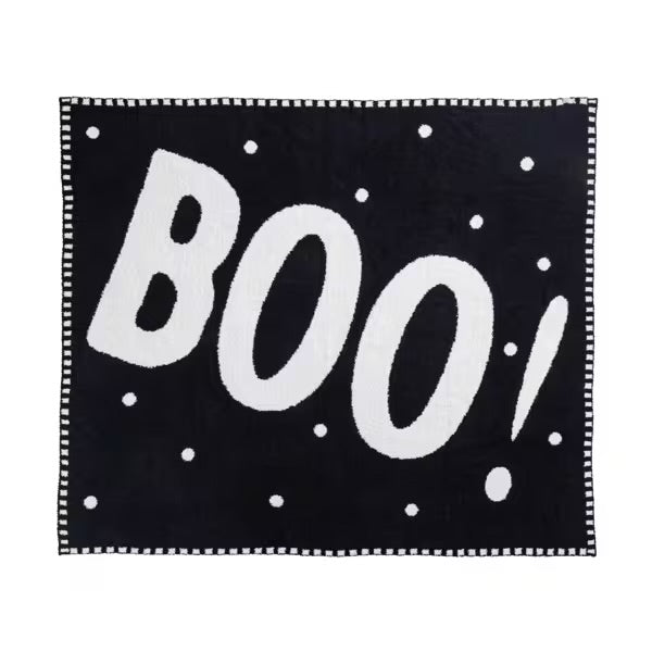 Black blanket with white 'BOO!' text and polka dots on a white background