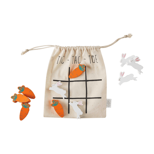A wooden Tic-Tac-Toe game set featuring three orange carrots with green tops, three white wooden rabbits, and a beige canvas drawstring bag printed with 'TIC - TAC - TOE' and a black grid.