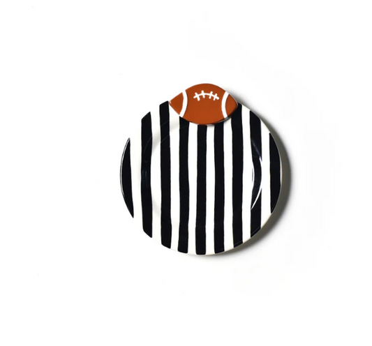 A round decorative plate featuring a black and white vertical stripe pattern with a small brown American football graphic on top, shown against a plain white background.