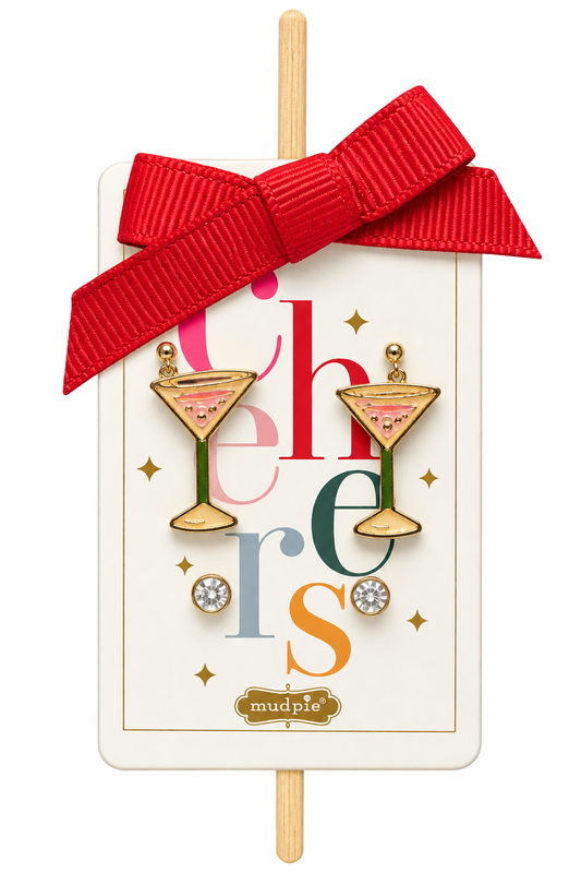 A pair of martini-themed earrings by mudpie, displayed on their original white gift card with a red ribbon bow. The earrings feature gold-plated frames with pink and green cocktail details and rhinestone accents.