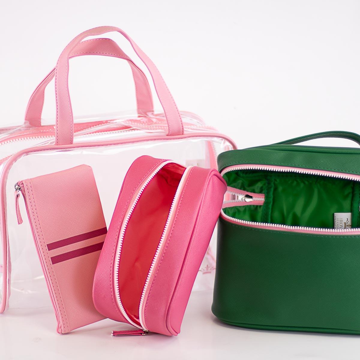 Pink, green, and clear zippered cosmetic and travel bags with top handles