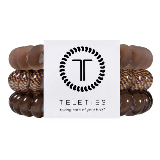 Three sets of Teleties hair beads in shades of brown, including solid dark brown, medium brown, and a brown-and-black patterned set, arranged behind a white brand card with the Teleties logo.