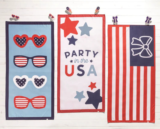 Three beach towels with patriotic designs on a white background