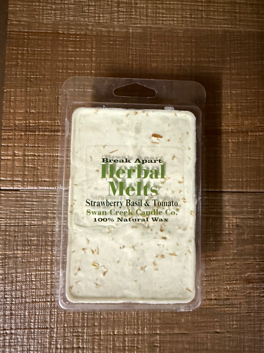 A packaged wax melt product labeled 'Herbal Melts' by Swan Creek Candle Co., shown in a clear plastic clamshell on a brown woven surface.